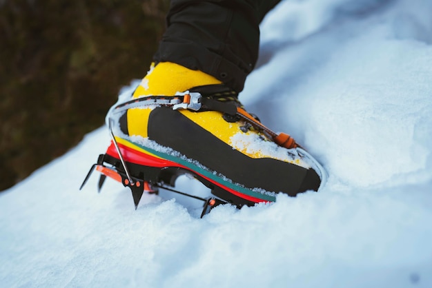 Premium Photo | Man climbing a snowy mountain with crampons