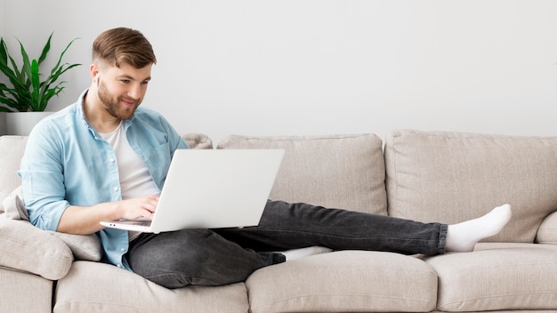 Free Photo | Man on couch with laptop