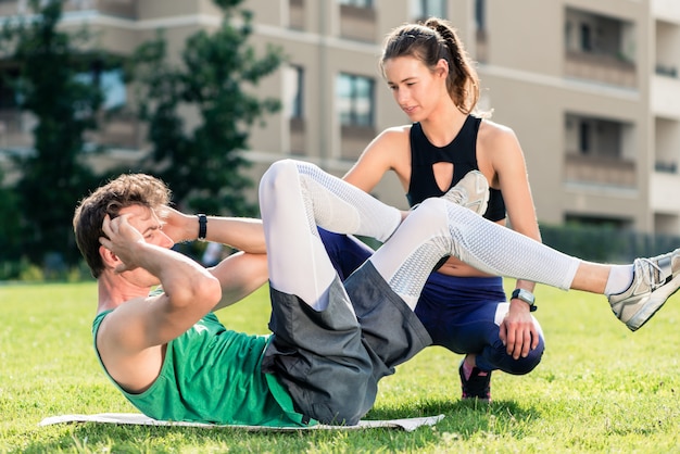 Premium Photo | Man doing crunches with fitness trainer