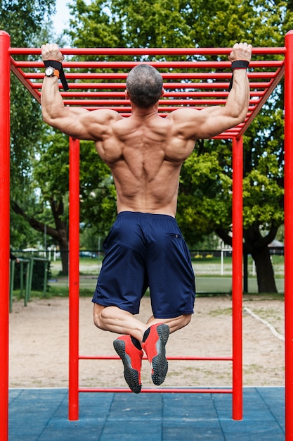 Premium Photo | Man Doing Pull-ups On Horizontal Bar