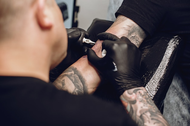 Free Photo | Man doing a tattoo in a tattoo salon