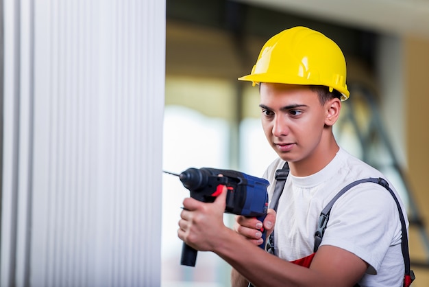 Man drilling the wall with drill perforator Premium Photo
