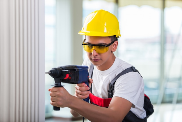 Man drilling the wall with drill perforator Premium Photo