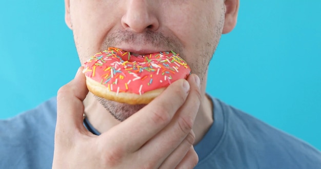 Premium Photo Man Eat Donut Closeup On Blue