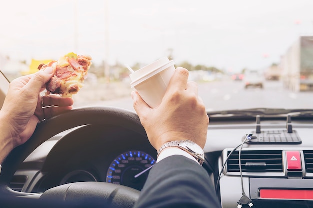 Free Photo Man Eating Pizza And Coffee While Driving Car Dangerously