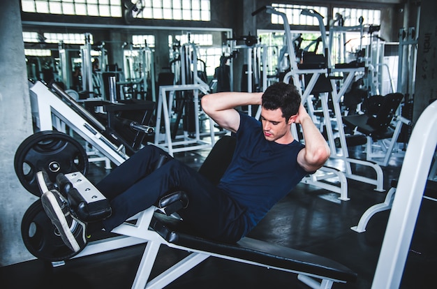 Premium Photo | Man exercising work out and flexing muscles in gym