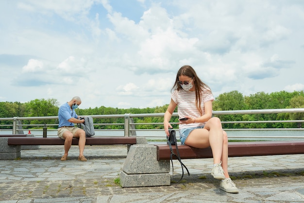 Premium Photo A Man In A Face Mask Is Sitting On A Bench Keeping A