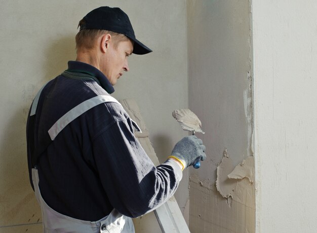 Premium Photo | Man gets manually gypsum plaster