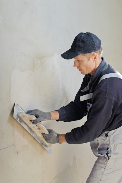 Premium Photo | Man gets manually gypsum plaster