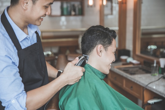 Premium Photo | Man getting haircut by hairdresser at barbershop