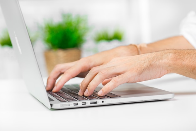 Man hand on laptop keyboard with blank screen monitor close up Premium Photo
