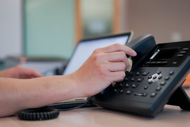 Man hand touching on handset telephone to calling Premium Photo