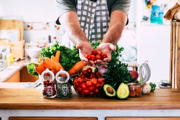 Premium Photo | Man hands show fresh vegetables and fruits on a table ...