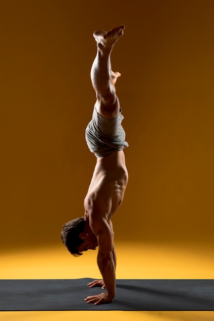 Free Photo Man In Handstand Pose On Yoga Mat