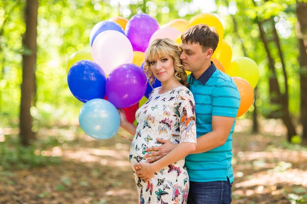 Premium Photo Man And His Pregnant Wife With Balloons Outdoors