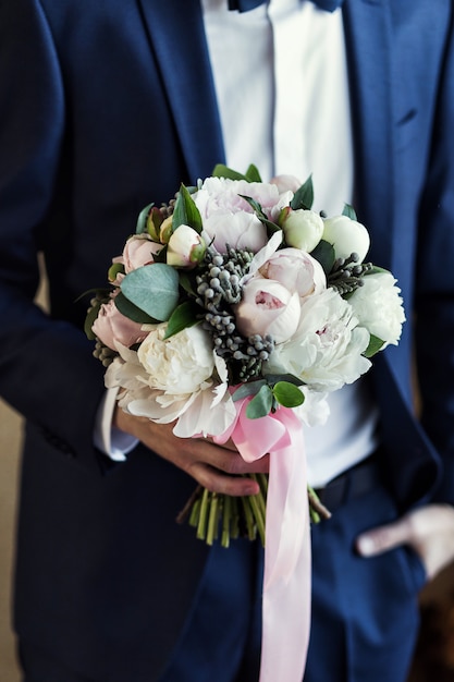 Premium Photo Man Holding Bridal Bouquet In Hands Groom Getting Ready In The Morning Before Wedding Ceremony