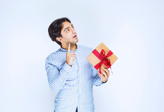 Free Photo Man Holding A Cardboard Gift Box With Red Ribbon And Thinking To Make A Decision High Quality Photo