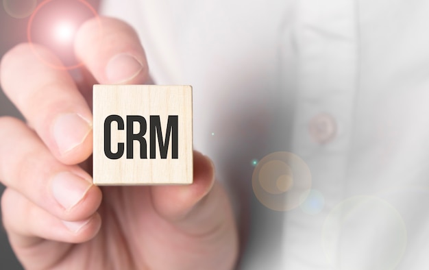 Man holding crm word on wooden cube. Premium Photo