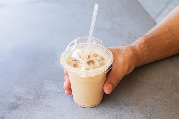 Premium Photo | Man holding iced coffee or latte in take away plastic