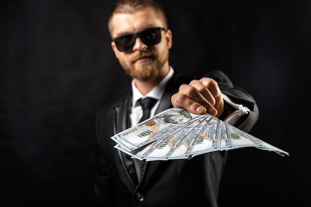 Premium Photo Man Holding Money In Hand At Black Background