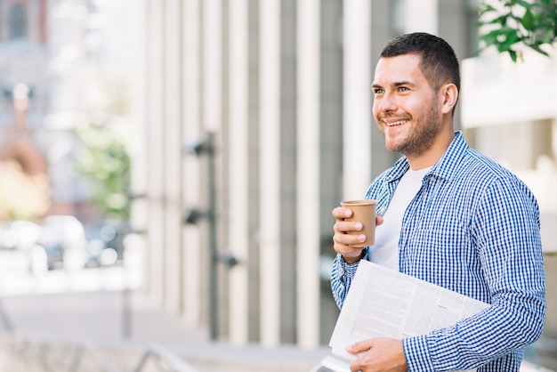 Free Photo Man Holding Newspaper And Coffee Near Building