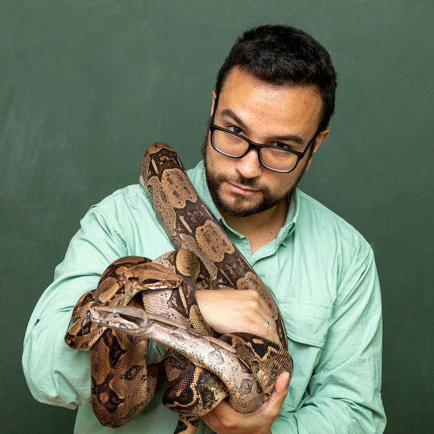 Premium Photo | Man holding a snake boa constrictor