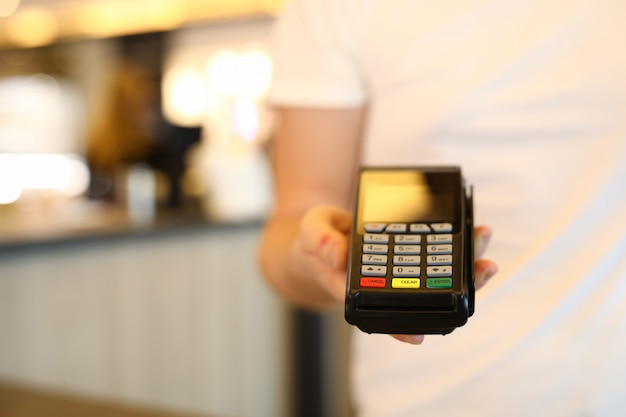 Premium Photo | Man holds commercial portable banking terminal