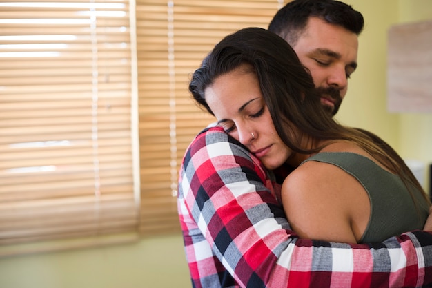 Man Hugging His Wife At Home Free Photo