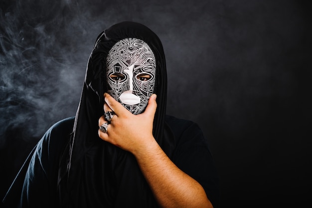 顔を覆うハロウィンのマスクの男 無料の写真
