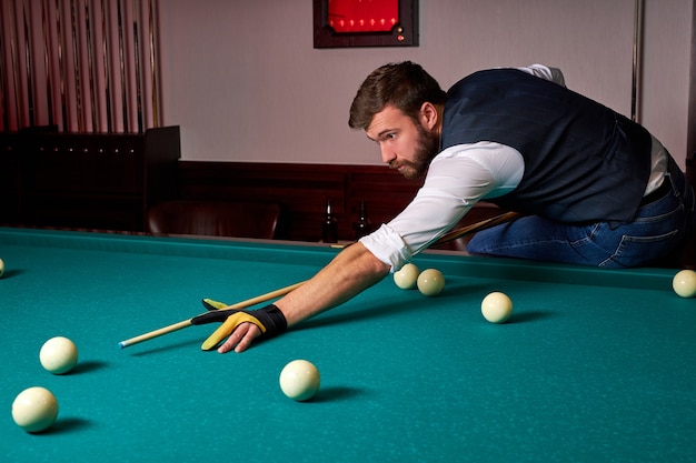 Premium Photo | Man is playing snooker, young male is ...