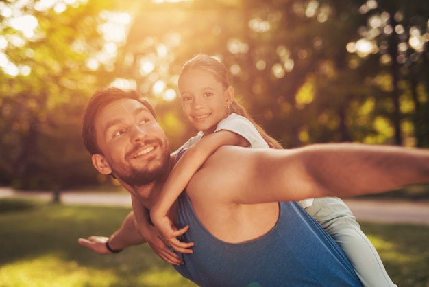 A Man Is Riding A Girl On His Shoulders In The Park Premium Photo