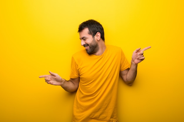 Man on isolated vibrant yellow color enjoy dancing while listening to music at a party Premium Photo