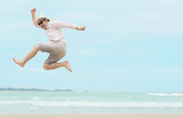 タイの海のビーチでの休暇中に幸せな男ジャンプ 無料の写真