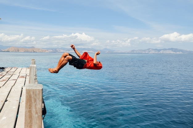 Premium Photo A Man Jumping Backflip Into The Sea Water