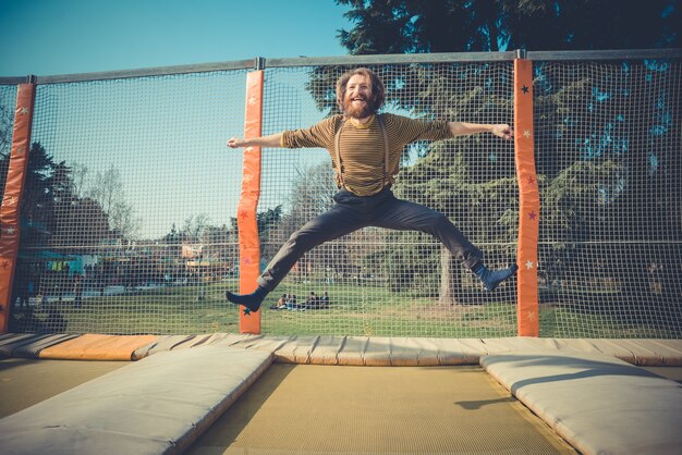 Premium Photo | Man jumping on trampoline at playground