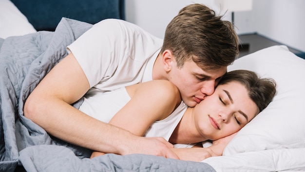 Free Photo | Man kissing sleeping woman on cheek