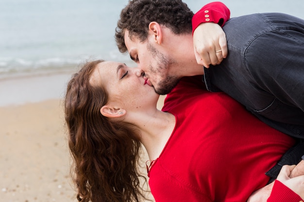 彼女を抱っこしている女性にキスする男 無料の写真