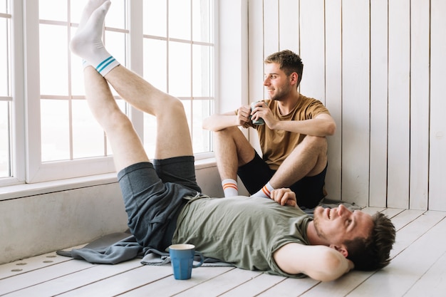 Man looking through window while his friend lying on floor Free Photo