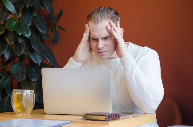 Premium Photo Man Looks In Horror At The Laptop Clings To His Head Headache From A Computer Screen Human Emotions Depreciation Of The Currency Businessman Accountant In Shock Lost Bet