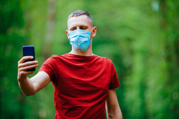 Premium Photo | A man makes a selfie in a mask on a forest background