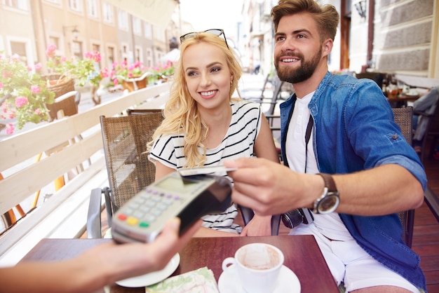 Man paying for the coffee with a credit card Free Photo