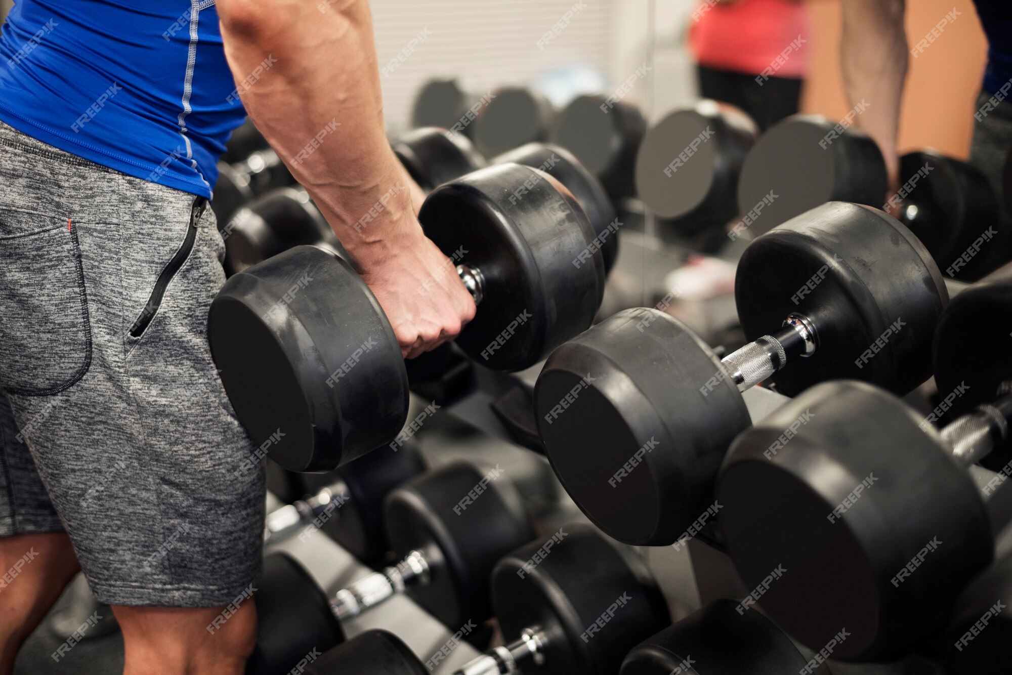 Free Photo | Man picking up weights from the rack