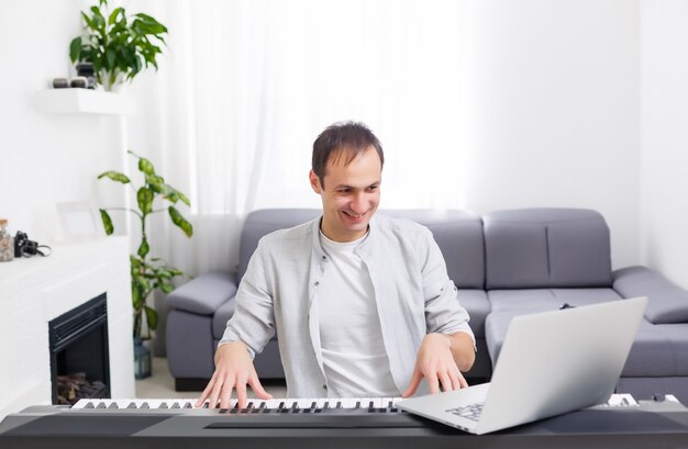 premium-photo-man-playing-music-with-piano-and-laptop