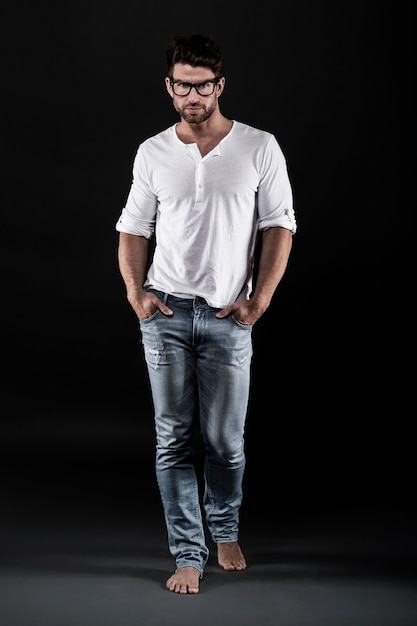 Free Photo | Man posing with eyeglasses, jeans and white t-shirt