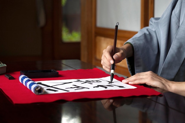 Free Photo | Man Practicing Japanese Handwriting With A Brush