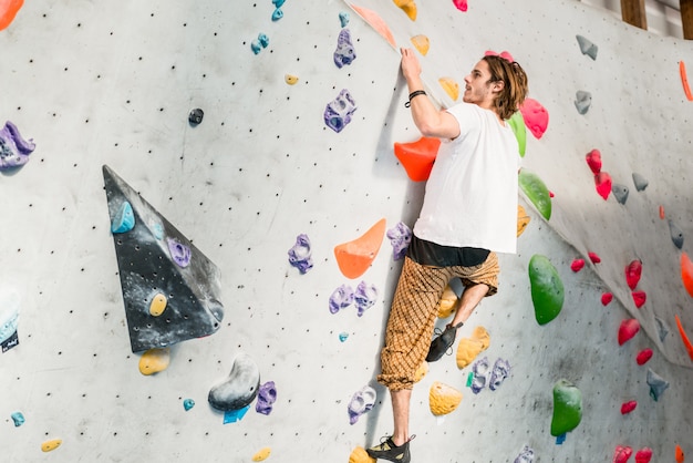 Premium Photo Man Practicing Rock Climbing On Artificial Wall