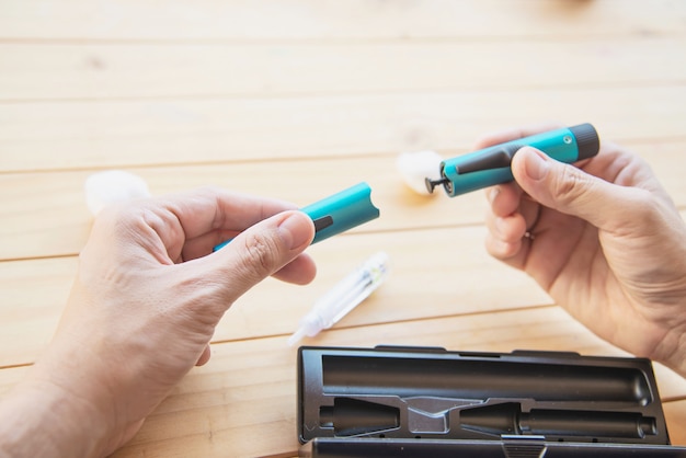 Man preparing insulin diabetic syringe for injection Free Photo