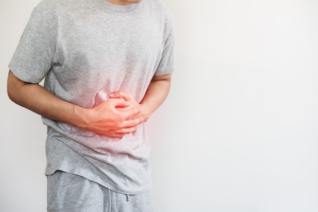 A man pressing his stomach, with red highlight of stomach pain and others stomach disease concept Premium Photo