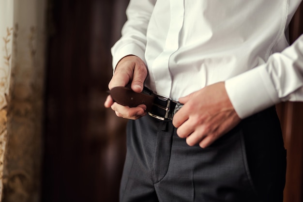 Premium Photo | Man putting on a belt, businessman, politician, man's ...