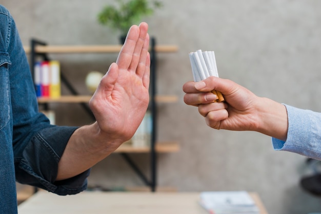 Man refusing bunch of cigarettes offered by his female friend Free Photo